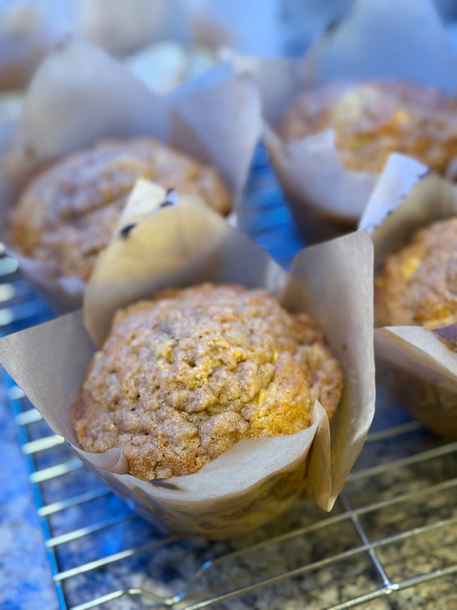 Butter Together’s freshly baked crumble-topped muffins cooling in parchment wrappers